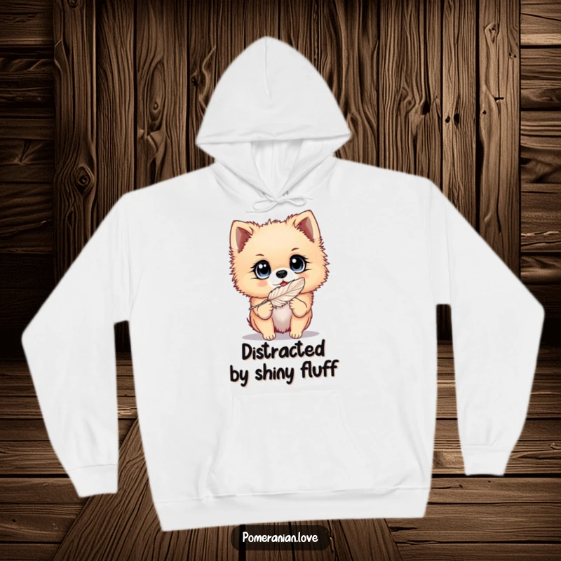 Funny Pomeranian hoodie featuring a dog with big, bright eyes playing with a feather, designed for cozy fun and playful vibes.