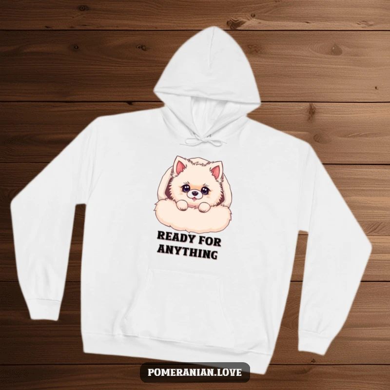 Funny Pomeranian hoodie, a fluffy dog peeking out of a soft bed, with bright, curious eyes, embodying cuteness.