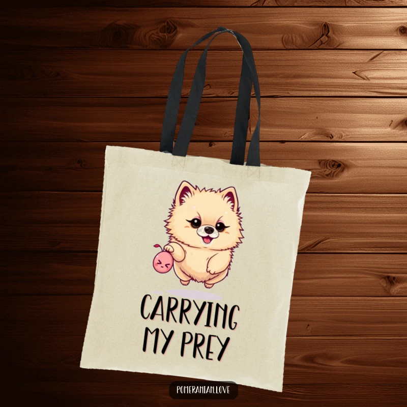 Funny tote bag featuring a determined Pomeranian leaping for a tiny squeaky toy, perfect for carrying essentials.